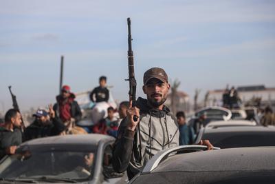 Displaced Palestinians travel in vehicles past rubble, as they attempt to return to their homes, in Rafah-stock-foto