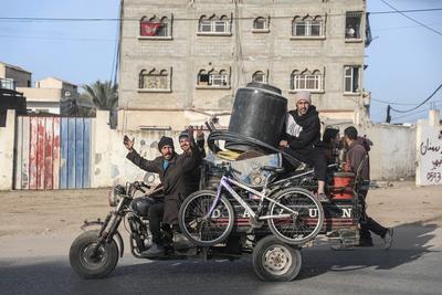 Displaced Palestinians travel in vehicles past rubble, as they attempt to return to their homes, in Rafah-stock-foto