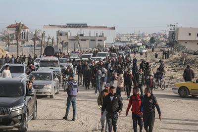 Displaced Palestinians travel in vehicles past rubble, as they attempt to return to their homes, in Rafah-stock-foto
