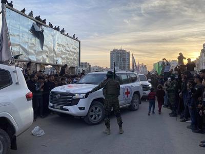 Palestinians gather near the site of the handover of the Israeli hostages to the International Committee of the Red Cross (ICRC)-stock-photo