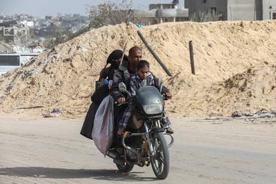 Displaced Palestinians travel in vehicles past rubble, as they attempt to return to their homes, in Rafah, in the southern Gaza Strip-stock-foto