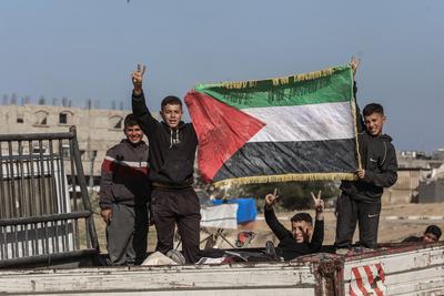 Displaced Palestinians travel in vehicles past rubble, as they attempt to return to their homes, in Rafah, in the southern Gaza Strip-stock-foto