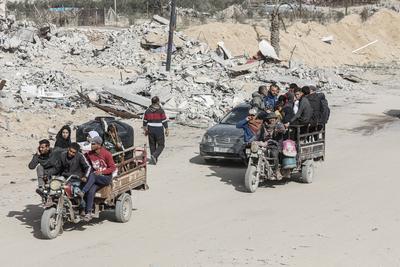 Displaced Palestinians travel in vehicles past rubble, as they attempt to return to their homes, in Rafah, in the southern Gaza Strip-stock-foto