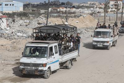 Displaced Palestinians travel in vehicles past rubble, as they attempt to return to their homes, in Rafah, in the southern Gaza Strip-stock-foto