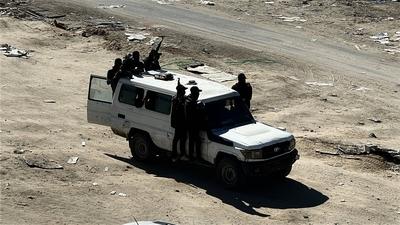 Security guards sit atop trucks carrying humanitarian aid coming in from the Kerem Shalom border crossing (also known as Karem Abu Salem-stock-foto