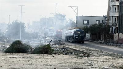 Security guards sit atop trucks carrying humanitarian aid coming in from the Kerem Shalom border crossing (also known as Karem Abu Salem-stock-foto