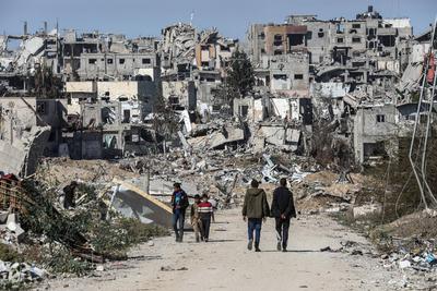 Displaced Palestinians continue to return their houses past heavily damaged and partially collapsed buildings after the ceasefire and hostage-prisoner swap deal between Hamas and Israel at Bureij-stock-photo