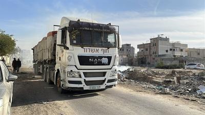 Security guards sit atop trucks carrying humanitarian aid coming in from the Kerem Shalom border crossing (also known as Karem Abu Salem-stock-foto