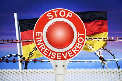 FOTOMONTAGE, Polizeikelle mit Aufschrift Stop Einreiseverbot vor Deutschlandfahne und Stacheldraht, Symbolfoto f?r Grenz-stock-foto