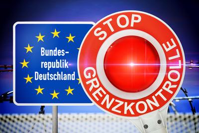FOTOMONTAGE, Grenzschild der Bundesrepublik Deutschland und Polizeikelle mit Aufschrift Stop Grenzkontrolle vor Stacheld-stock-foto