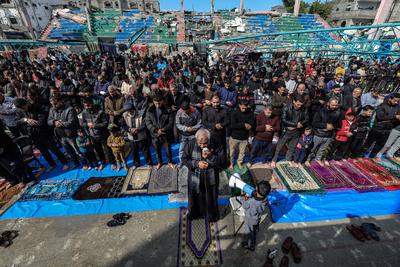 Palestinians perform Friday prayers at the Al-Bureij Services Club stadium, which was destroyed by Israeli airstrikes on the Al-Burei-stock-photo
