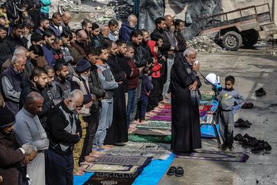 Palestinians perform Friday prayers at the Al-Bureij Services Club stadium, which was destroyed by Israeli airstrikes on the Al-Burei-stock-photo