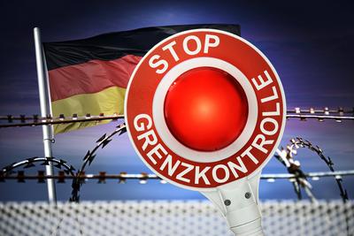 FOTOMONTAGE, Polizeikelle mit Aufschrift Stop Grenzkontrolle und Deutschlandfahne vor Stacheldraht, Symbolfoto f?r Grenz-stock-foto