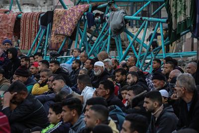 Palestinians perform Friday prayers at the Al-Bureij Services Club stadium, which was destroyed by Israeli airstrikes on the Al-Burei-stock-photo