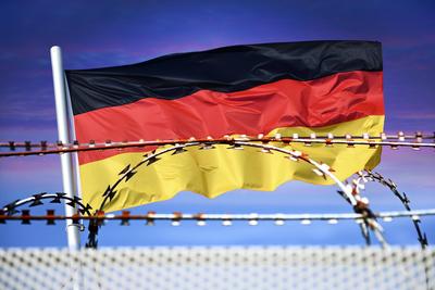 FOTOMONTAGE, Deutschlandfahne vor Stacheldraht, Symbolfoto f?r Grenzkontrollen und Zur?ckweisung an den deutschen Landes-stock-foto