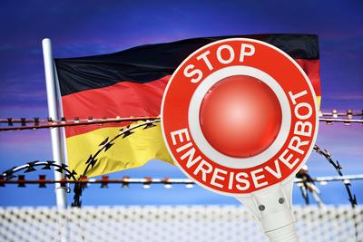 FOTOMONTAGE, Polizeikelle mit Aufschrift Stop Einreiseverbot vor Deutschlandfahne und Stacheldraht, Symbolfoto f?r Grenz-stock-foto