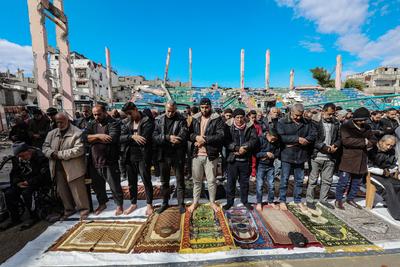 Palestinians perform Friday prayers at the Al-Bureij Services Club stadium, which was destroyed by Israeli airstrikes on the Al-Burei-stock-photo