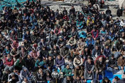 Palestinians perform Friday prayers at the Al-Bureij Services Club stadium, which was destroyed by Israeli airstrikes on the Al-Burei-stock-photo