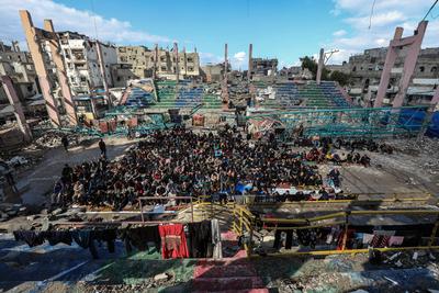 Palestinians perform Friday prayers at the Al-Bureij Services Club stadium, which was destroyed by Israeli airstrikes on the Al-Burei-stock-photo