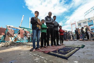 Palestinians perform Friday prayers at the Al-Bureij Services Club stadium, which was destroyed by Israeli airstrikes on the Al-Burei-stock-photo