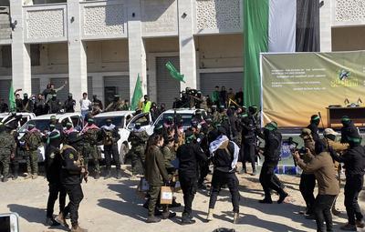 Hamas fighters secure an area in a square before handing over four Israeli hostages to a Red Cross team in Gaza-stock-foto