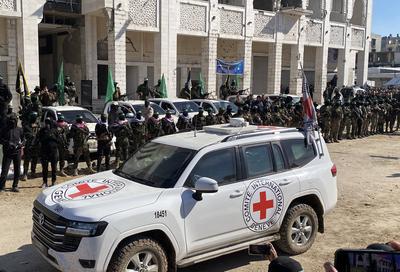 Hamas fighters secure an area in a square before handing over four Israeli hostages to a Red Cross team in Gaza-stock-foto