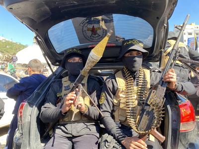 Hamas fighters secure an area in a square before handing over four Israeli hostages to a Red Cross team in Gaza-stock-foto