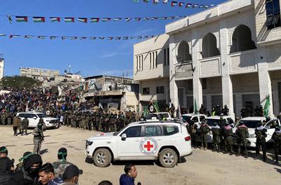 Hamas fighters secure an area in a square before handing over four Israeli hostages to a Red Cross team in Gaza-stock-foto