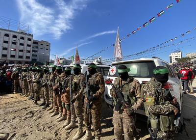 Hamas fighters secure an area in a square before handing over four Israeli hostages to a Red Cross team in Gaza-stock-foto