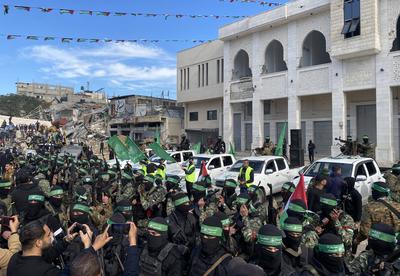 Hamas fighters secure an area in a square before handing over four Israeli hostages to a Red Cross team in Gaza-stock-foto