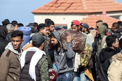 Palestinians wait to be allowed to return to their homes in northern Gaza after they were displaced to the south at Israel's order during the war, amid a ceasefire between Israel and Hamas, in the central Gaza-stock-photo