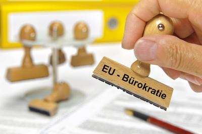 EU-B?rokratie Eine Hand h?lt einen Holzstempel mit der Aufschrift: EU-B?rokratie *** EU Bureaucracy A hand holds a woode-stock-foto