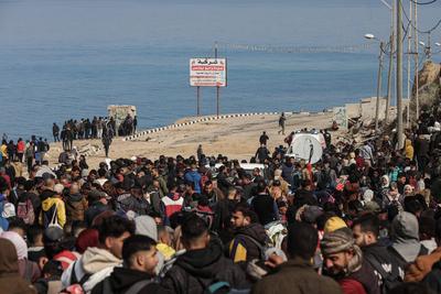 Palestinians wait to be allowed to return to their homes in northern Gaza after they were displaced to the south at Israel's order during the war, amid a ceasefire between Israel and Hamas, in the central Gaza-stock-foto