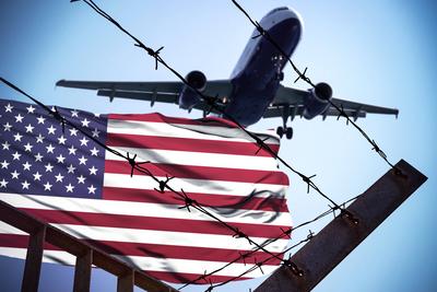 22 January 2025: Symbolic image for deportations from the USA. In the foreground barbed wire and the American flag, abov-stock-photo