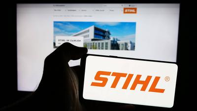 Person holding mobile phone with logo of German power equipment company Stihl Holding AG Co. KG. Stuttgart, Germany - 08-stock-foto