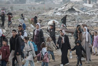Palestinians, who were displaced to the south at Israel's order during the war, make their way back to their homes in northern Gaza, amid a ceasefire between Israel and Hamas, in the central Gaza Strip-stock-foto