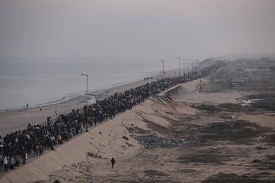 Palestinians, who were displaced to the south at Israel's order during the war, make their way back to their homes in northern Gaza, amid a ceasefire between Israel and Hamas, in the central Gaza Strip-stock-foto