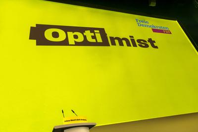 Dreik?nigstreffen 2025 der FDP in Stuttgart. Leeres Rednerpult. Gro?plakat mit der Aufschrift Optimist. // 06.01.2024: S-stock-foto