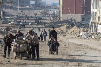 Carrying their belongings displaced Palestinians walk on a road to return to their homes in the northern Gaza Strip-stock-foto