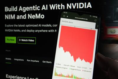Auf einem Laptop wurde die Website der Nvidia Corporation ge?ffnet. Davor wurde auf eimem Smartphone der dramatisch eing-stock-foto