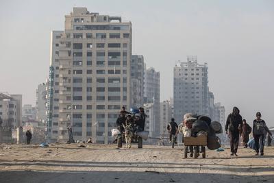 Carrying their belongings displaced Palestinians walk on a road to return to their homes in the northern Gaza Strip-stock-foto