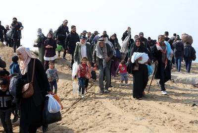 Displaced Palestinians making their way back on foot from the southern regions to their homes in the north via Al Rashid Road-stock-foto