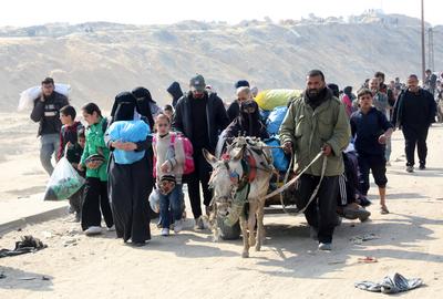 Displaced Palestinians making their way back on foot from the southern regions to their homes in the north via Al Rashid Road-stock-foto