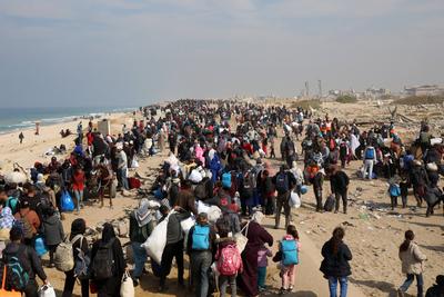 Displaced Palestinians making their way back on foot from the southern regions to their homes in the north via Al Rashid Road-stock-foto
