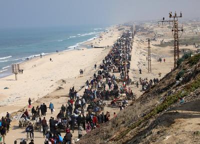 Displaced Palestinians making their way back on foot from the southern regions to their homes in the north via Al Rashid Road-stock-foto