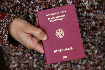 Deutscher Reisepass - Symbolbild Einb?rgerung DEU, Deutschland, Hamburg: Ein Frau mit Migrationswurzeln h?lt ihren deuts-stock-photo