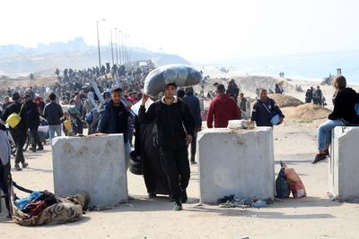 Displaced Palestinians making their way back on foot from the southern regions to their homes in the north via Al Rashid Road-stock-foto