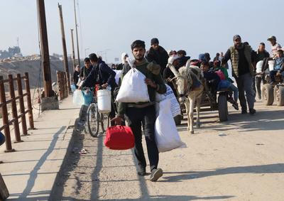 Displaced Palestinians making their way back on foot from the southern regions to their homes in the north via Al Rashid Road-stock-foto