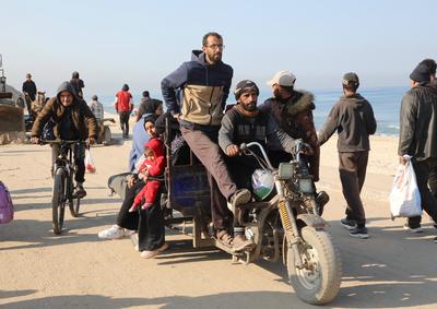 Displaced Palestinians making their way back on foot from the southern regions to their homes in the north via Al Rashid Road-stock-foto