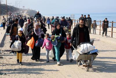 Displaced Palestinians making their way back on foot from the southern regions to their homes in the north via Al Rashid Road-stock-foto